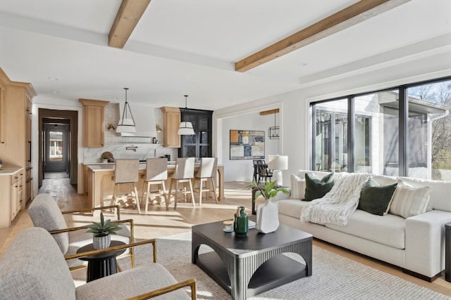 living room featuring beam ceiling and light wood-type flooring