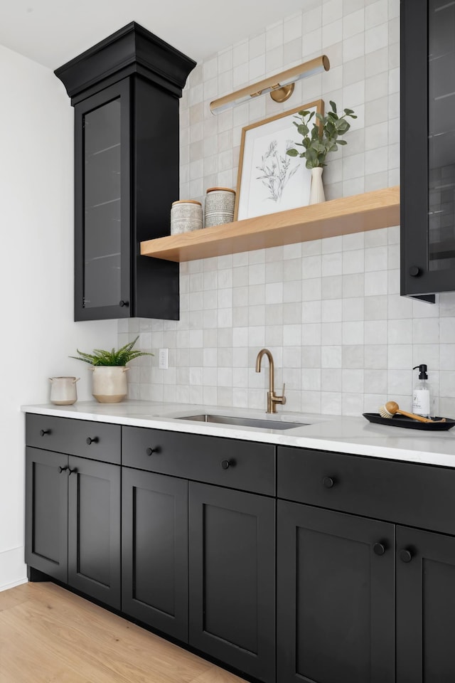 kitchen featuring backsplash, gray cabinets, light hardwood / wood-style flooring, and sink