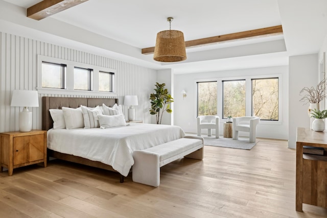 bedroom with beamed ceiling and light wood-type flooring