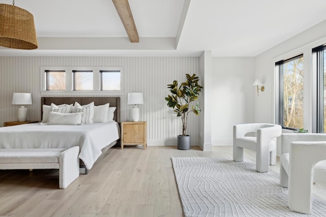 bedroom with beamed ceiling and light wood-type flooring