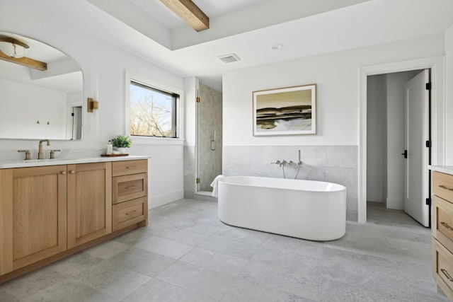 bathroom with beam ceiling, tile patterned flooring, separate shower and tub, vanity, and tile walls