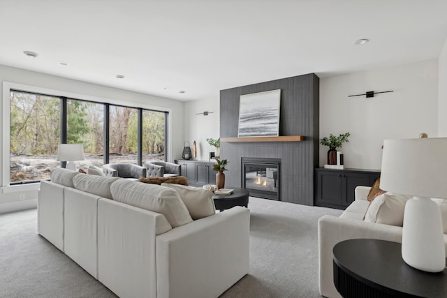 living room with a large fireplace and light colored carpet