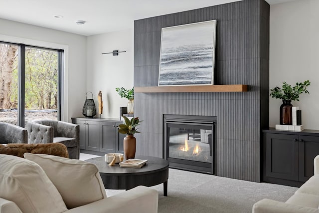 living room featuring a fireplace and light colored carpet