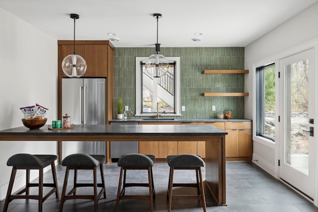 kitchen featuring decorative light fixtures, stainless steel appliances, tasteful backsplash, and sink