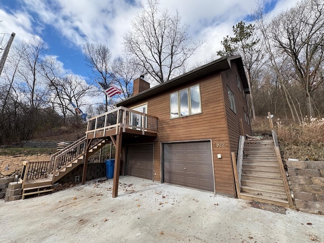 view of property exterior with a garage and a deck