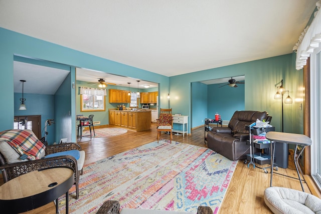 living room featuring light hardwood / wood-style flooring, ceiling fan, and lofted ceiling