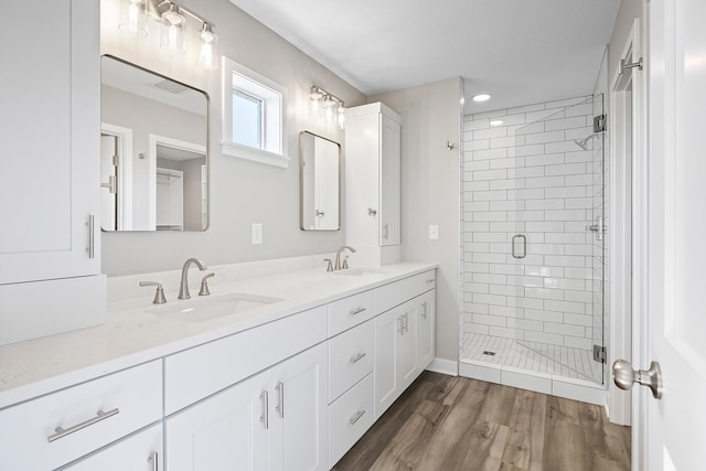 bathroom with hardwood / wood-style floors, vanity, and walk in shower