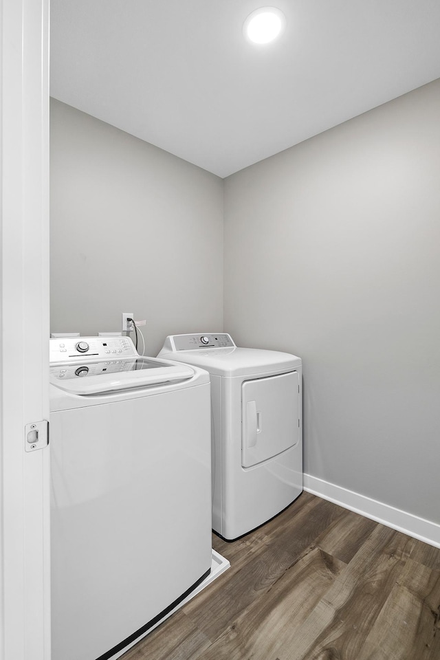 clothes washing area featuring dark hardwood / wood-style flooring and washing machine and clothes dryer