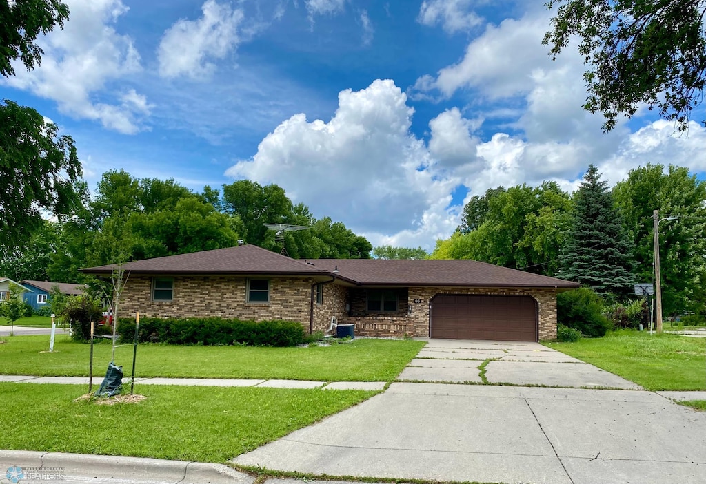 single story home with a garage and a front lawn