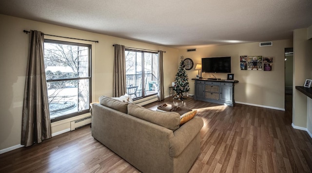 living room with wood-type flooring, a textured ceiling, and a baseboard heating unit