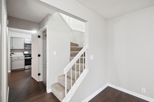 staircase featuring wood-type flooring and a textured ceiling