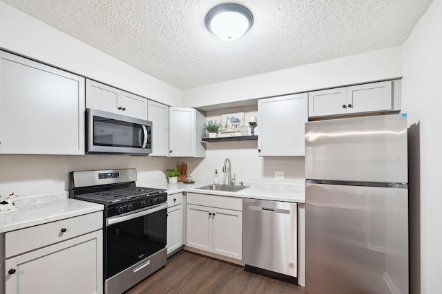 kitchen with a textured ceiling, dark hardwood / wood-style flooring, sink, and appliances with stainless steel finishes