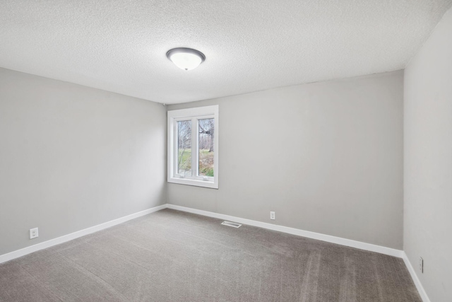 carpeted spare room with a textured ceiling