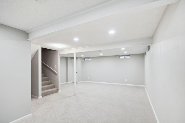 basement with light colored carpet and a textured ceiling