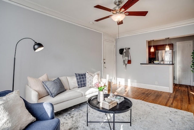 living room with crown molding, ceiling fan, and dark wood-type flooring