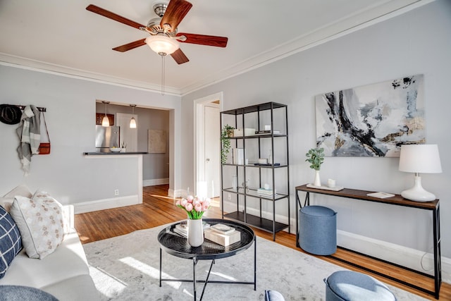 living room featuring ceiling fan, ornamental molding, and hardwood / wood-style flooring