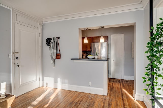 foyer entrance featuring crown molding and hardwood / wood-style flooring