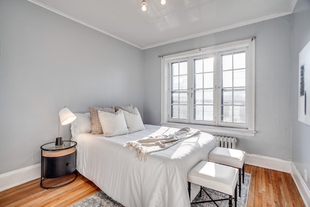 bedroom featuring radiator, hardwood / wood-style floors, and ornamental molding