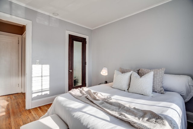 bedroom with hardwood / wood-style floors and ornamental molding