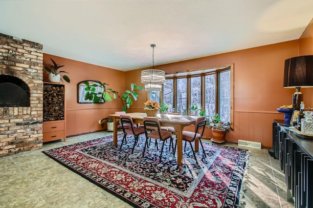 dining room featuring a chandelier, a wainscoted wall, and visible vents