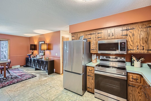 kitchen featuring appliances with stainless steel finishes, brown cabinets, and light countertops