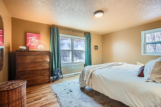 bedroom featuring a textured ceiling and light wood-style floors