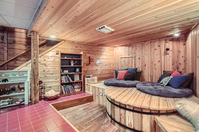 tiled bedroom featuring visible vents, wood ceiling, and wooden walls