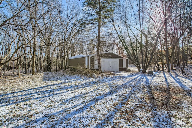 view of snowy exterior with an outdoor structure