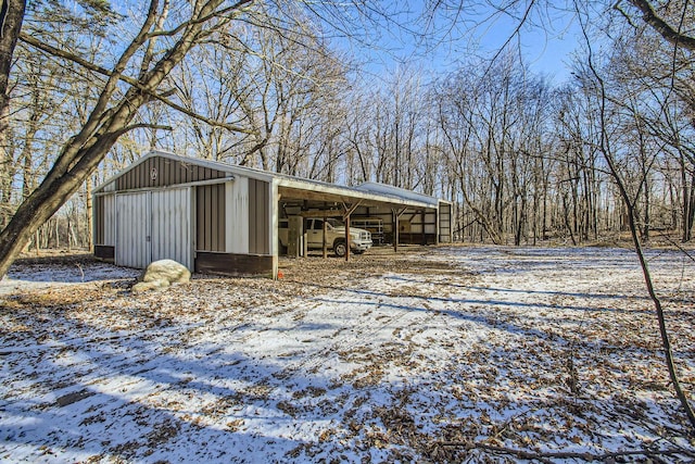 snow covered structure featuring an outbuilding and an outdoor structure