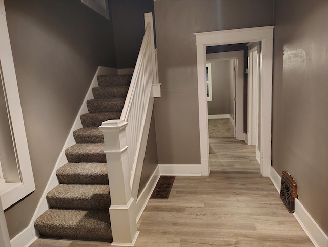 stairs featuring hardwood / wood-style floors