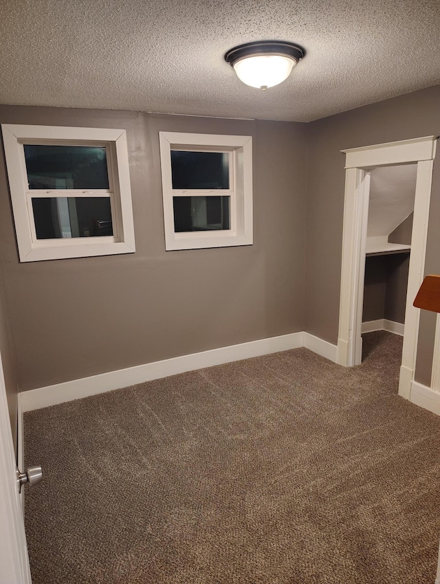 spare room featuring carpet flooring and a textured ceiling