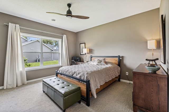 bedroom with a textured ceiling, ceiling fan, and light carpet