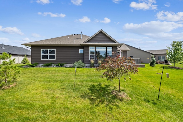 rear view of house featuring a lawn