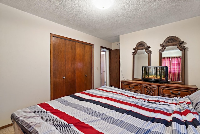 carpeted bedroom with a closet and a textured ceiling