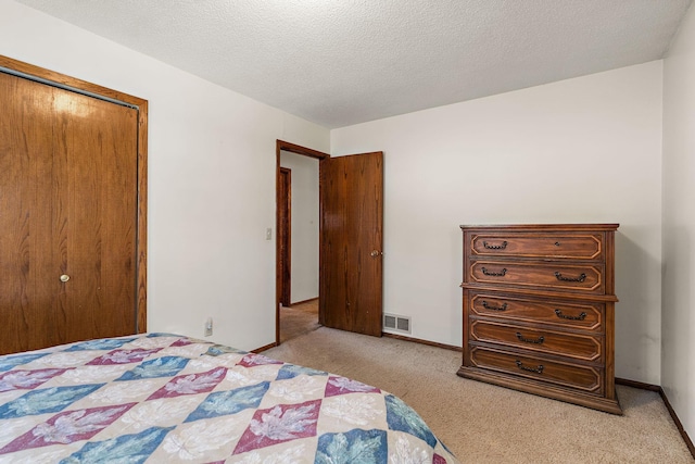 bedroom with light carpet, a textured ceiling, and a closet