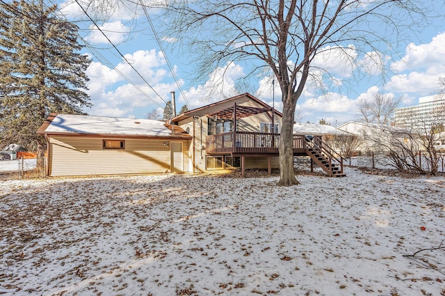 snow covered rear of property featuring a wooden deck