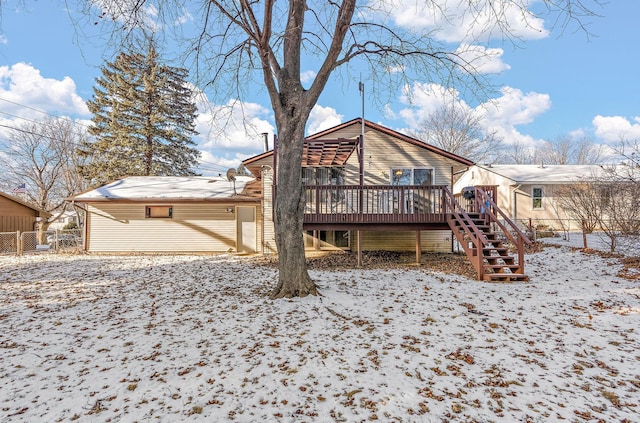 snow covered back of property featuring a deck