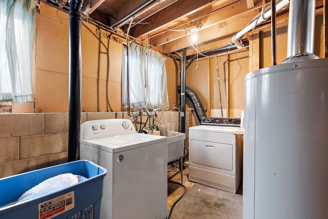 washroom featuring washing machine and clothes dryer, sink, and water heater