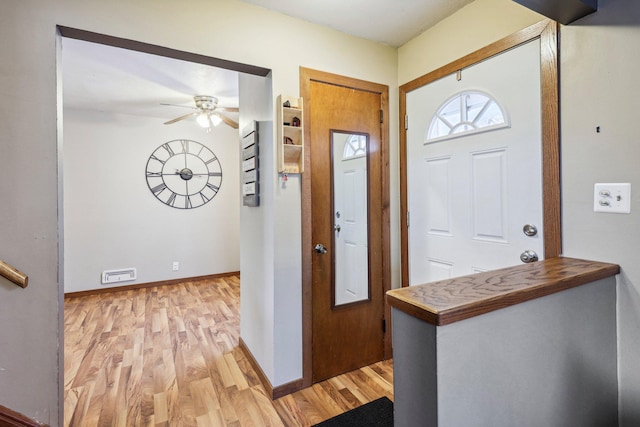 foyer entrance featuring ceiling fan and light wood-type flooring