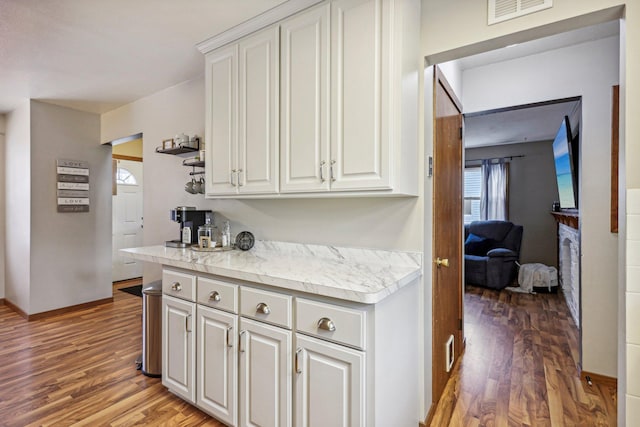 kitchen with wood-type flooring and white cabinetry