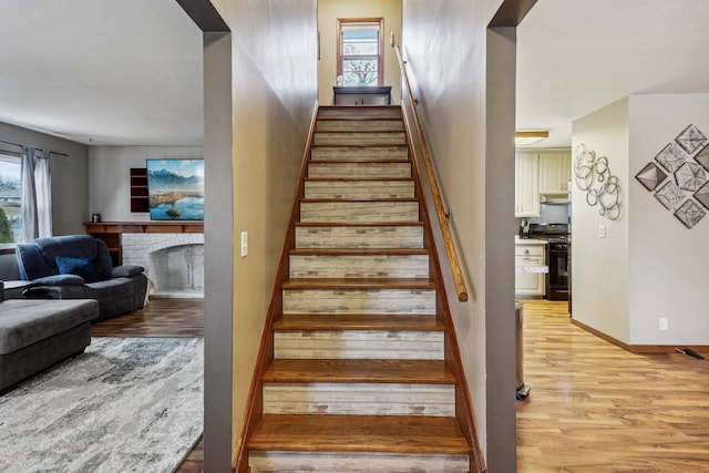 staircase featuring a fireplace and hardwood / wood-style floors