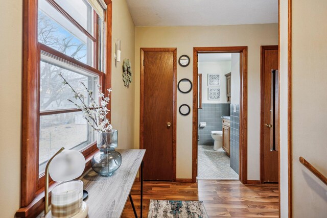 hall with dark hardwood / wood-style flooring and tile walls