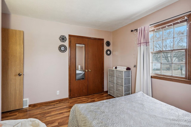 bedroom with a closet and dark wood-type flooring