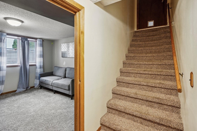 stairs with carpet flooring and a textured ceiling