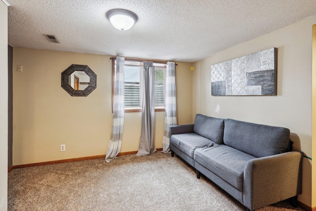 living room featuring carpet and a textured ceiling