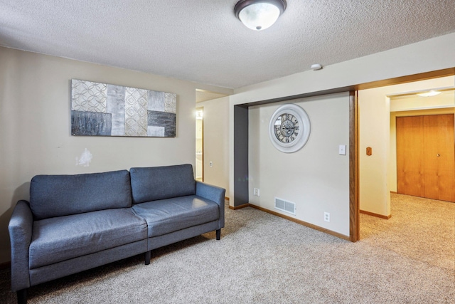 living room featuring light carpet and a textured ceiling