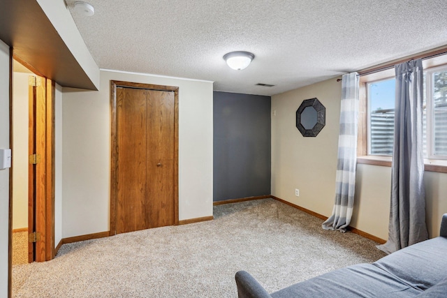 unfurnished bedroom with a closet, light colored carpet, and a textured ceiling