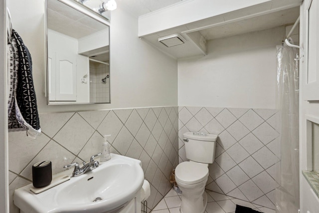 bathroom with tile patterned floors, sink, toilet, ornamental molding, and tile walls