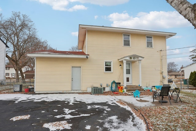 rear view of property with central air condition unit and a patio