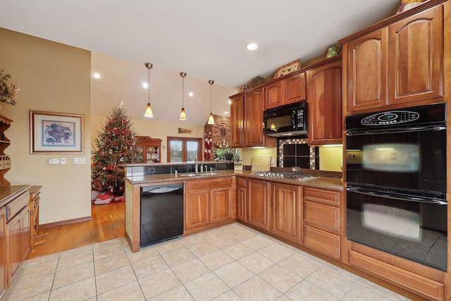 kitchen featuring black appliances, sink, kitchen peninsula, and light tile patterned floors